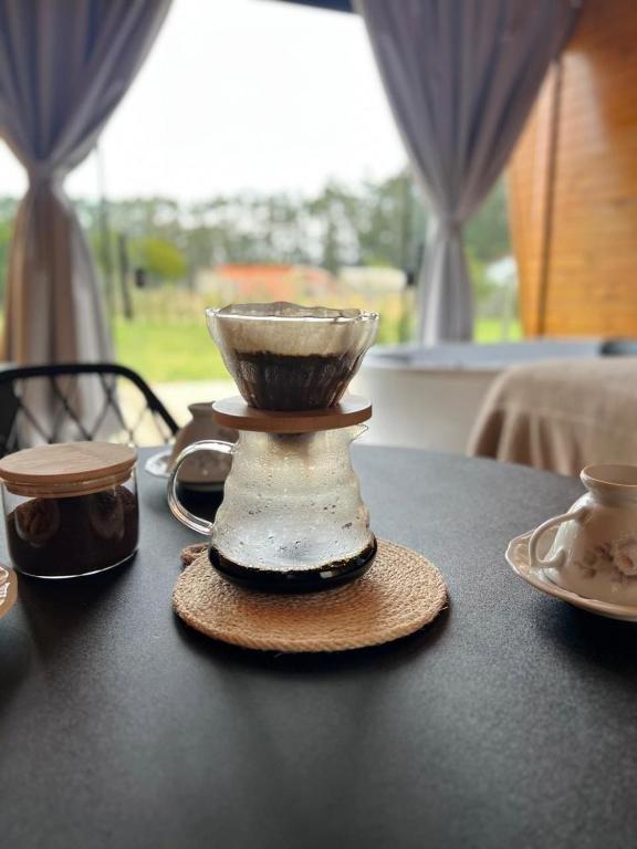 a tea pot on a table with two cups at Chalé Tiny house com banheira e lareira in Osório