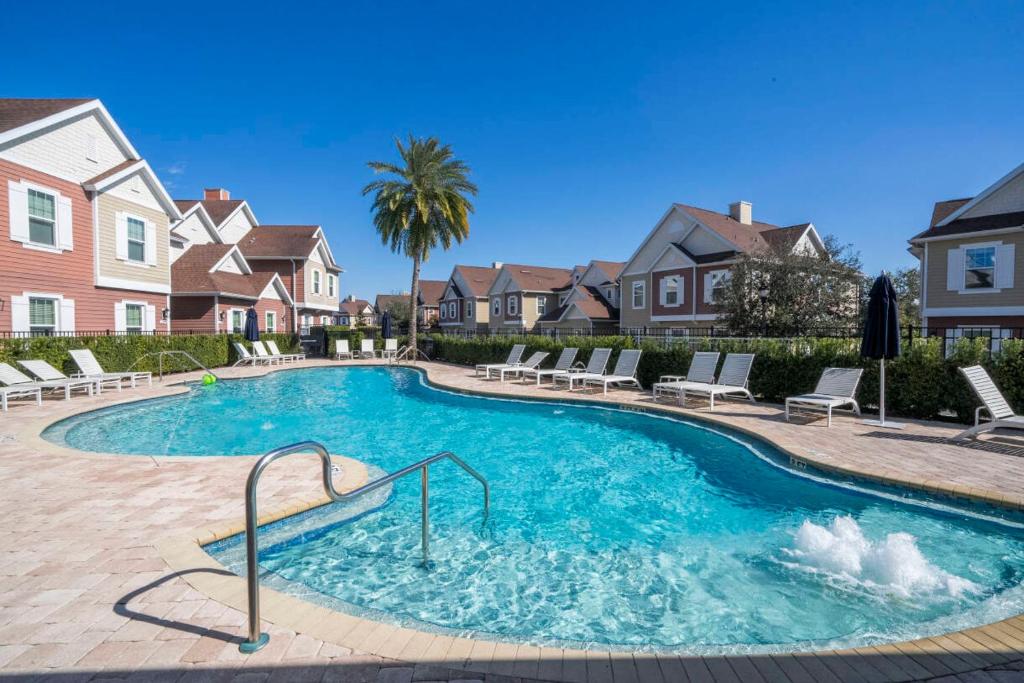 a swimming pool in a yard with chairs and houses at Magic Villa Orlando in Orlando