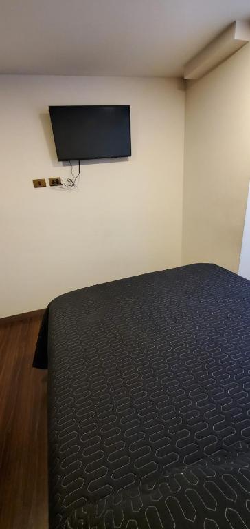 a bedroom with a bed and a flat screen tv at Monoambiente 12 in La Paz