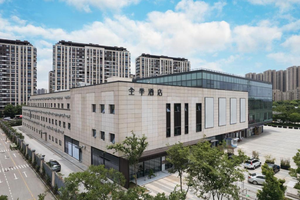 een gebouw in een stad met hoge gebouwen bij JI Hotel Suzhou Dushu Lake Ecological Park in Suzhou