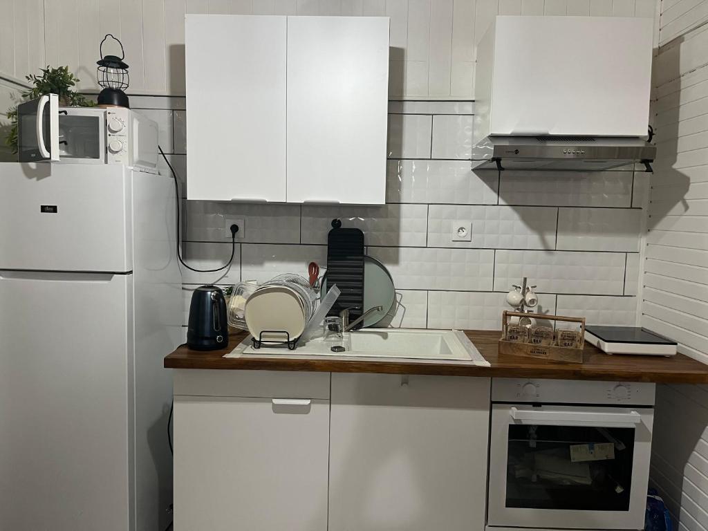 a kitchen with white cabinets and a white refrigerator at La BEL KREOL in Le Gosier