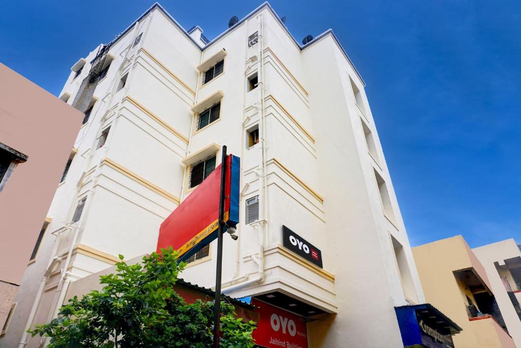 a tall white building with a sign on it at Hotel O Jaihind Building in Pune
