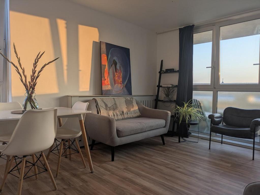 Stylish 1 Bedroom Flat in Old Street في لندن: غرفة معيشة بها أريكة وطاولة