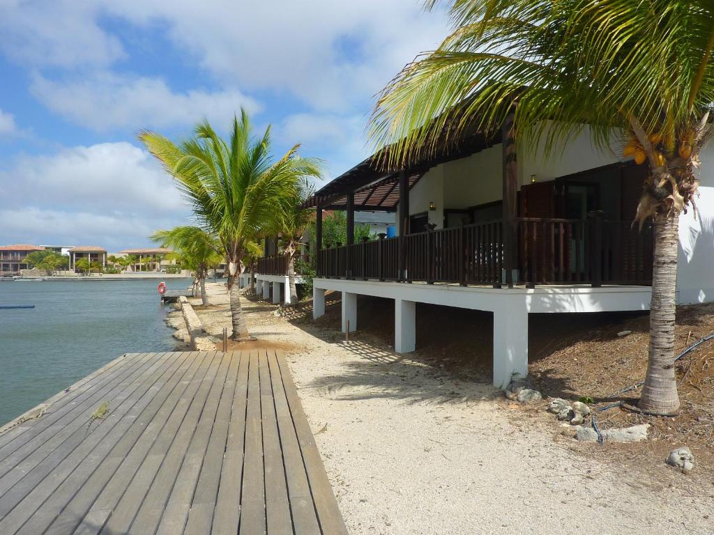 a building on a beach with palm trees and the water at AquaVilla Bonaire in Kralendijk