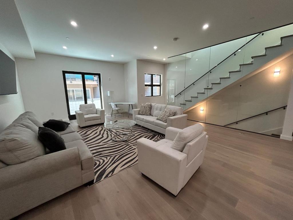 a living room with white furniture and a staircase at 906 Brand new townhome sleeps 10 in Redwood City
