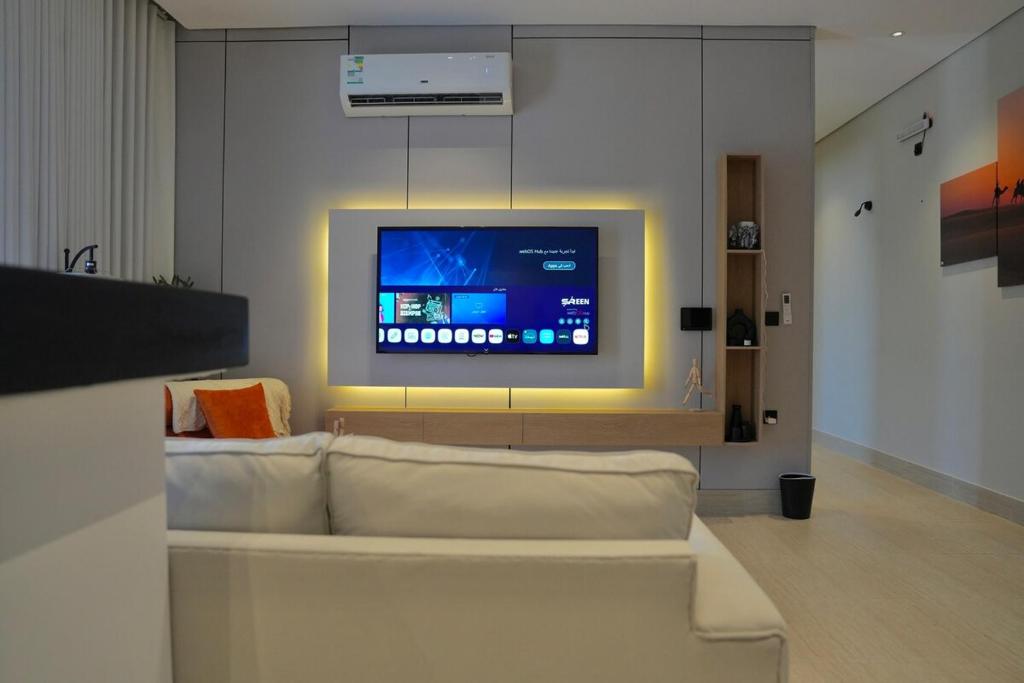 Una sala de estar con un sofá blanco y un televisor. en Peace House, en Medina