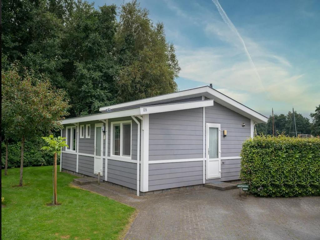 a small house with a garage in a yard at Scenic Holiday Chalet in Drenthe in Midlaren
