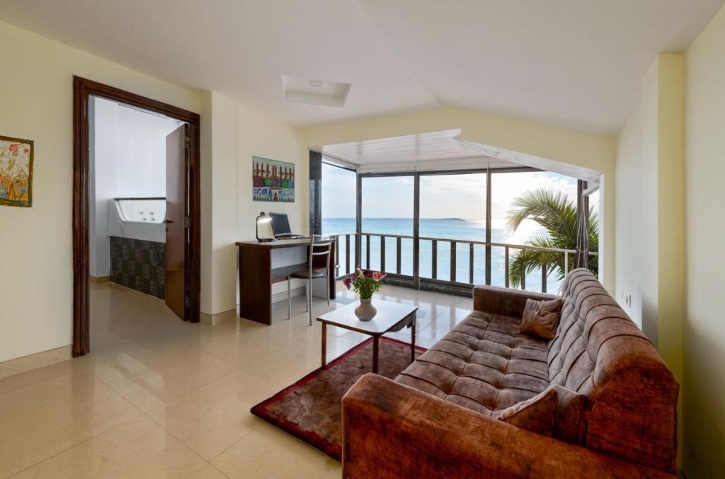 un soggiorno con divano e vista sull'oceano di Collection O Ziva Resort Near Calangute Beach a Calangute