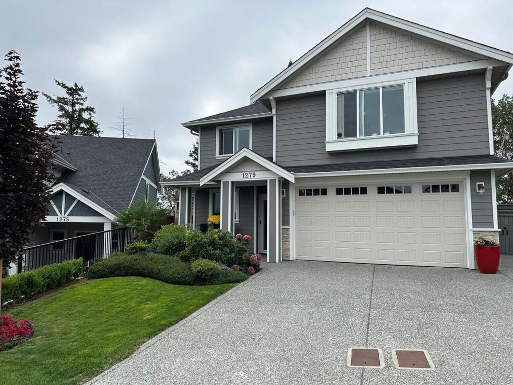 a gray house with a garage and a driveway at Modern One-Bedroom Retreat in Bear Mountain in Langford