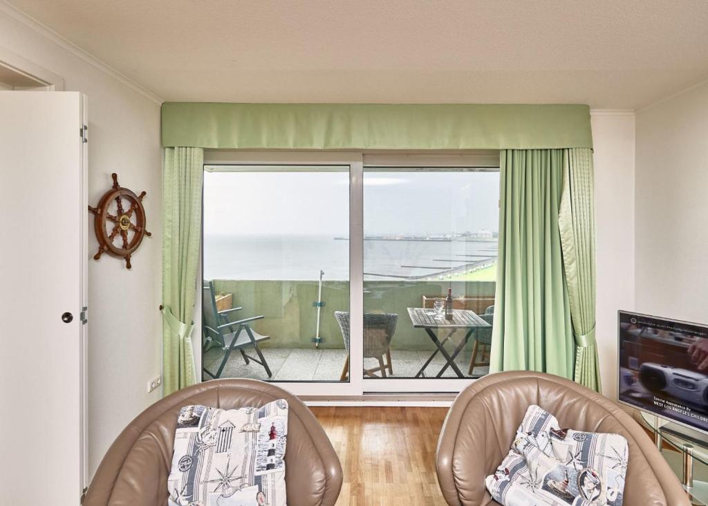 a living room with two chairs and a view of the ocean at Nautic - 812 in Cuxhaven