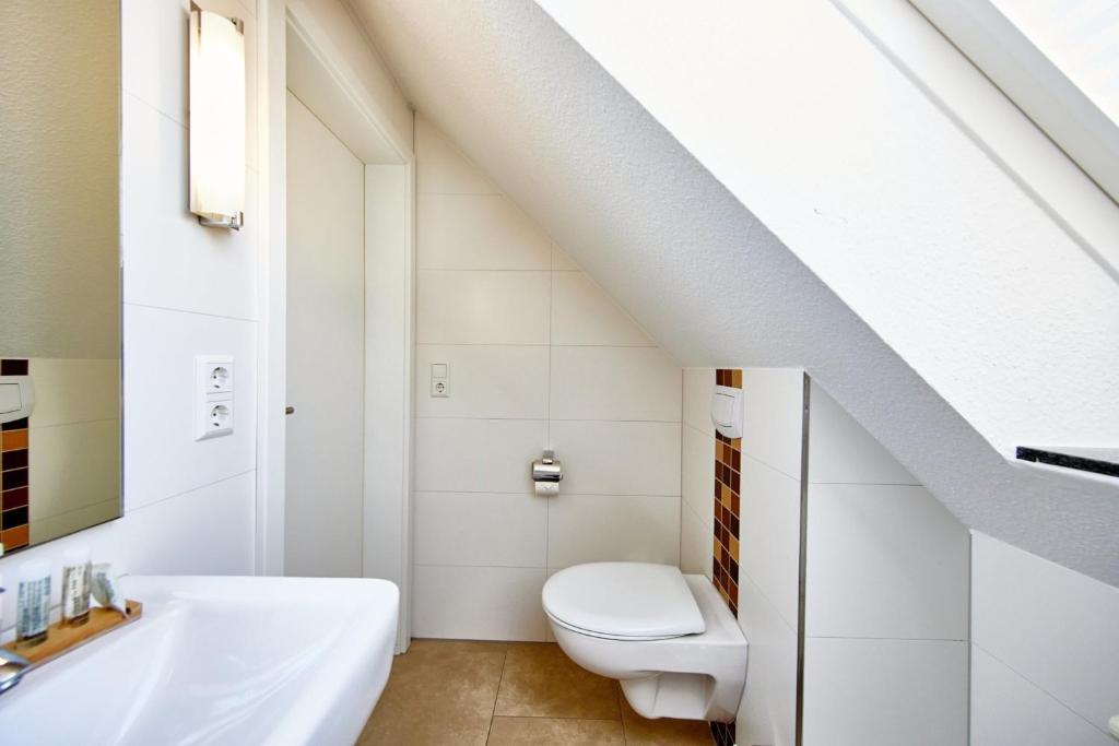 a bathroom with a white toilet and a sink at Residenz Seegras - 5 in Cuxhaven