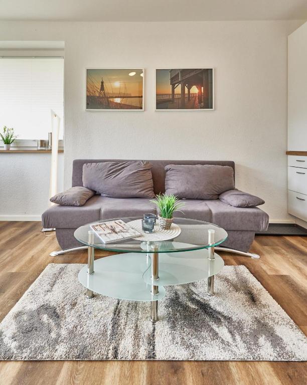 a living room with a couch and a glass table at Meerauszeit in Cuxhaven