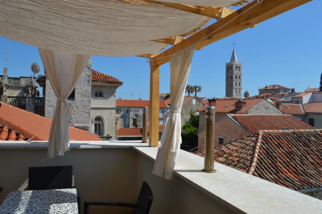 a balcony with a view of the roofs of a city at Four Towers Apartments in Rab