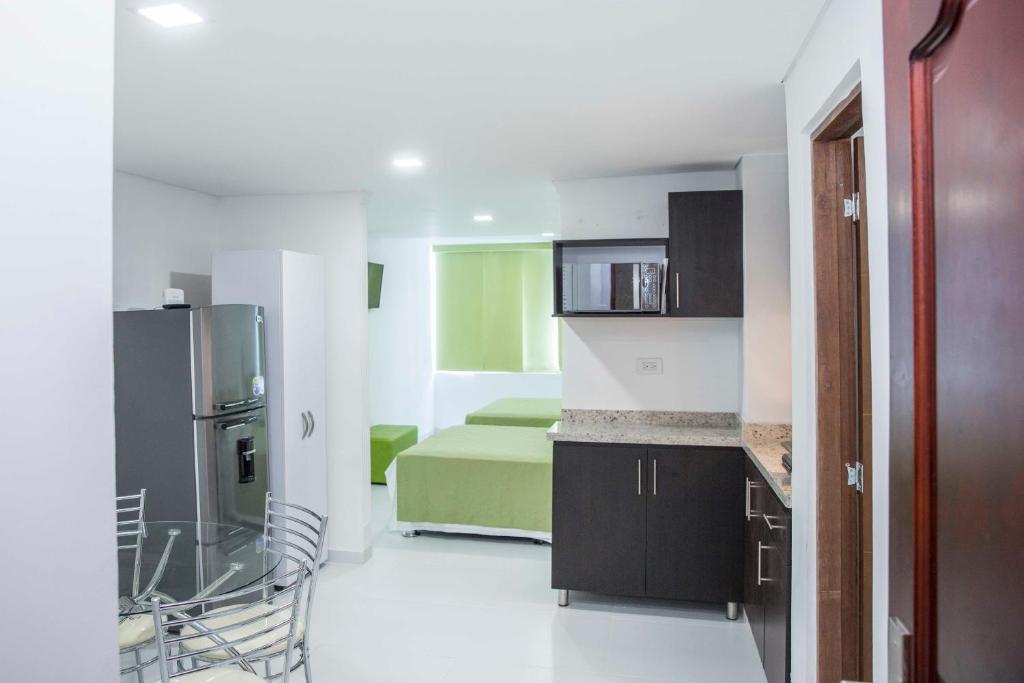 cocina con nevera y habitación con cama en Apartamento 1904 El Laguito, en Cartagena de Indias