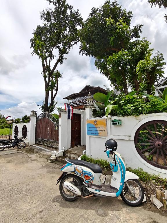 a scooter parked in front of a house at Boon Homestay & Cafe บุญโฮมสเตย์ in Ban Buak Khang