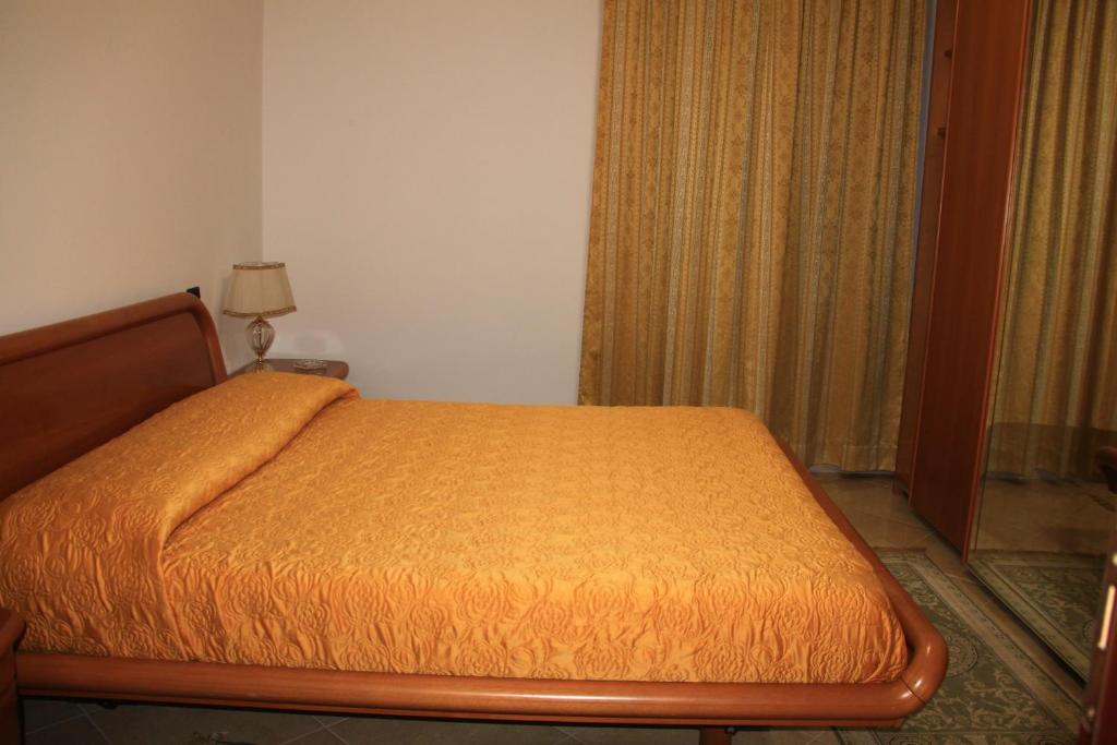 a bedroom with a bed with an orange bedspread at B&B La Piccola Oasi in Lazzaro