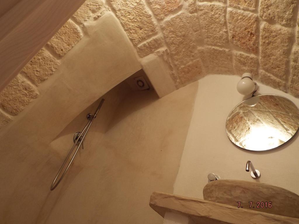 a bathroom with a sink and a mirror on a wall at 30 Metri Quadri in Ostuni