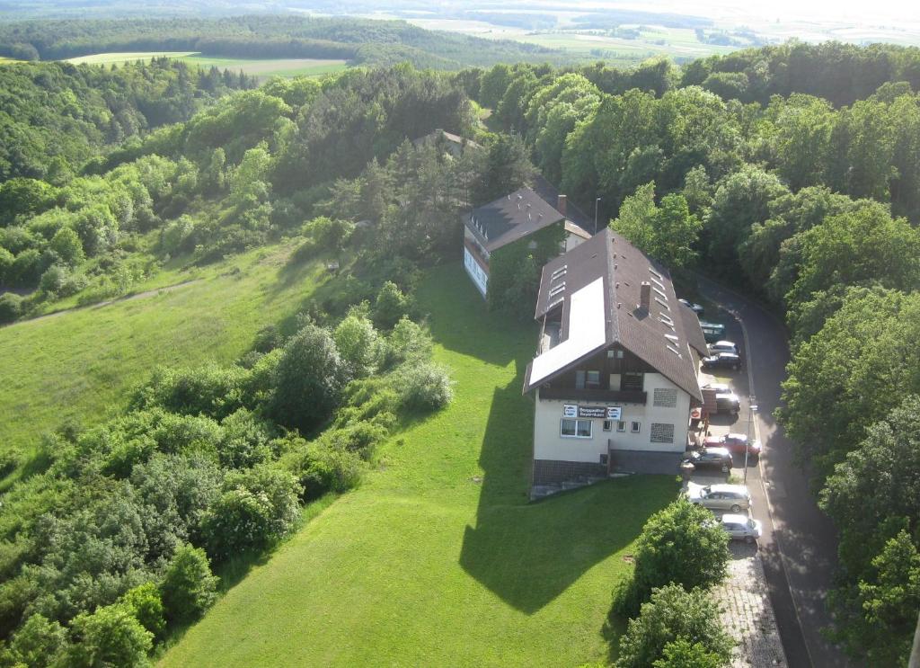an aerial view of a house on a grassy hill at Berggasthof Bayernturm in Zimmerau