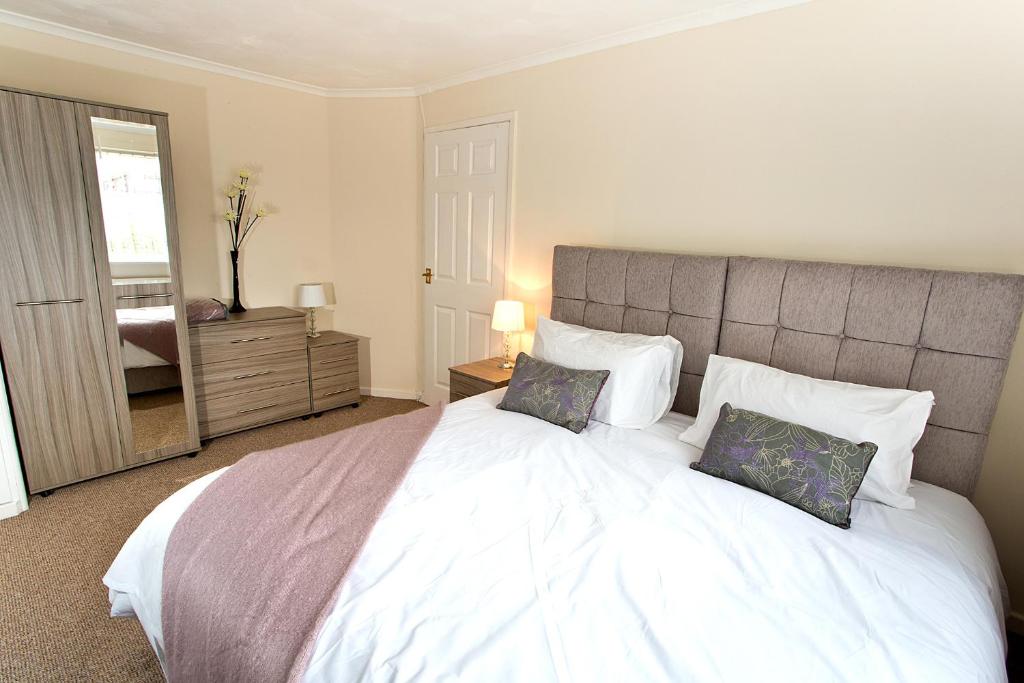 um quarto com uma grande cama branca e 2 almofadas em Ripley Peak District Gateway em Ripley