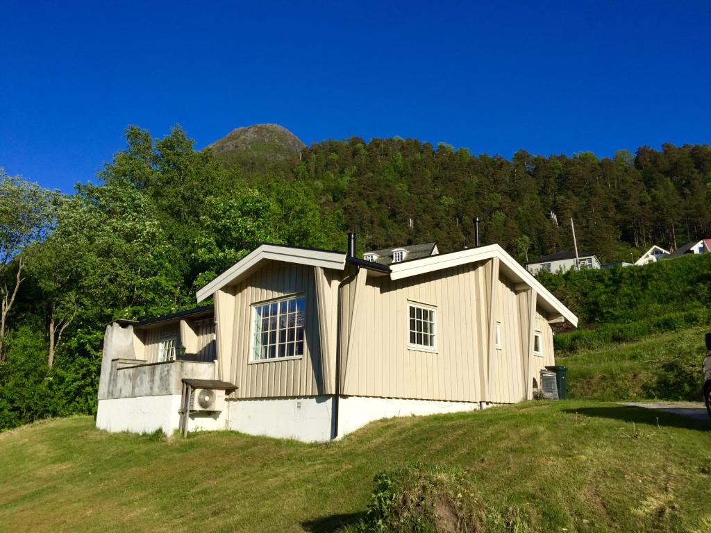 a small house on top of a grassy hill at Villa Haudalan Åndalsnes in Åndalsnes