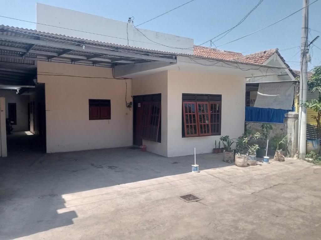 a small white house with a large courtyard at Oseng Pesona House in Ketapang