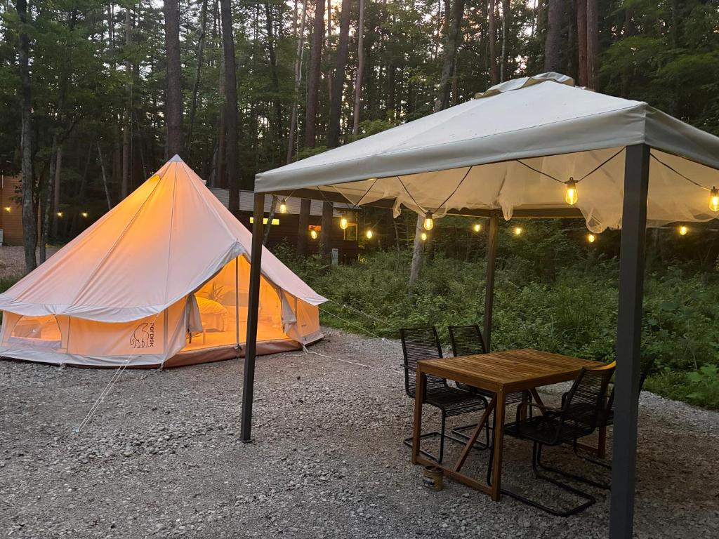 富士河口湖町にあるFuji Campのテントとその前にテーブルと椅子がある