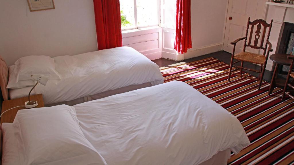 1 dormitorio con 2 camas, silla y ventana en Armadale House Scotland Farr North Coast B&B, en Armadale