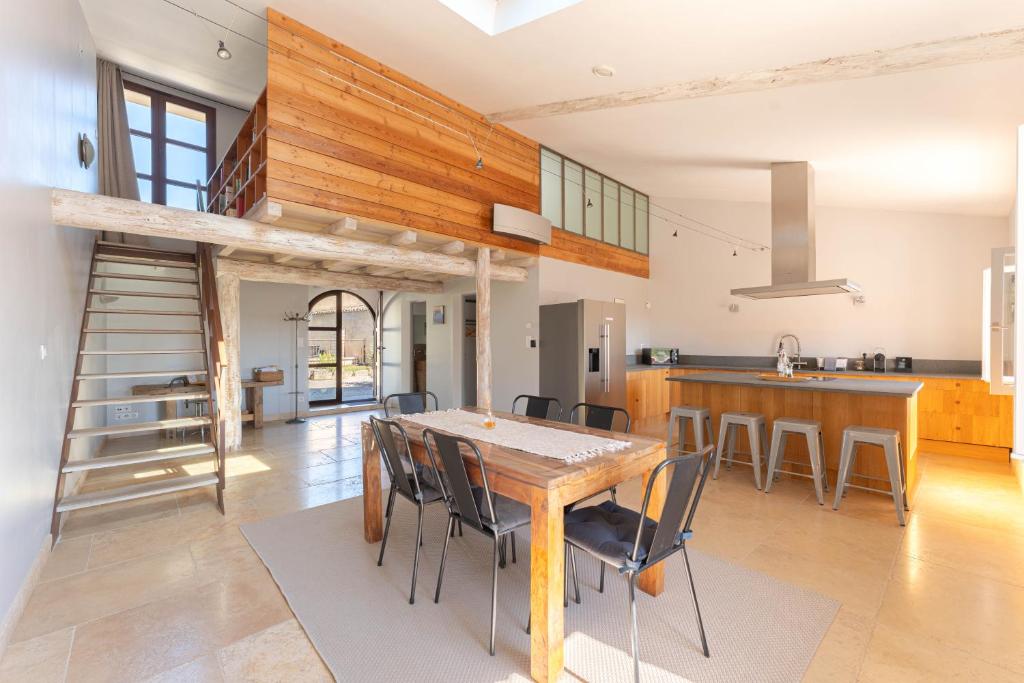 eine Küche und ein Esszimmer mit einem Holztisch und Stühlen in der Unterkunft Ferme La Clavière, Maison de vacances Lou Mas in Mane