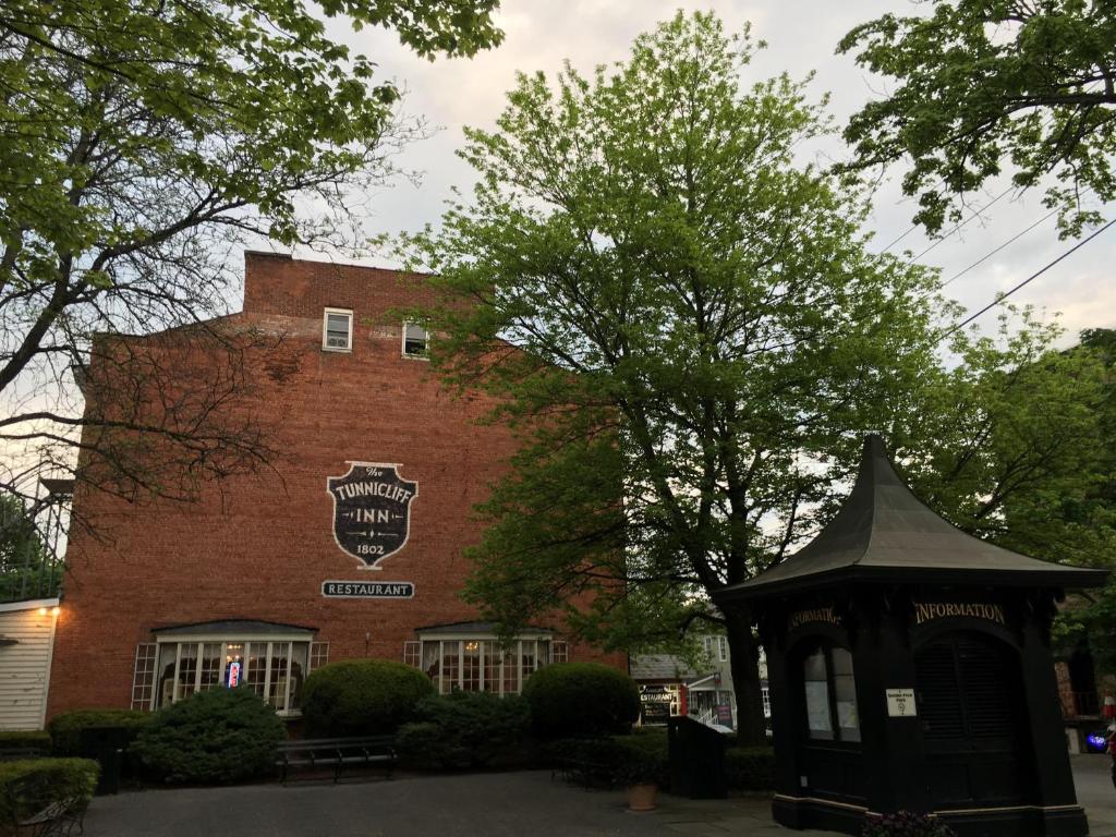 a brick building with a gazebo in front of it at The Tunnicliff Inn in Cooperstown