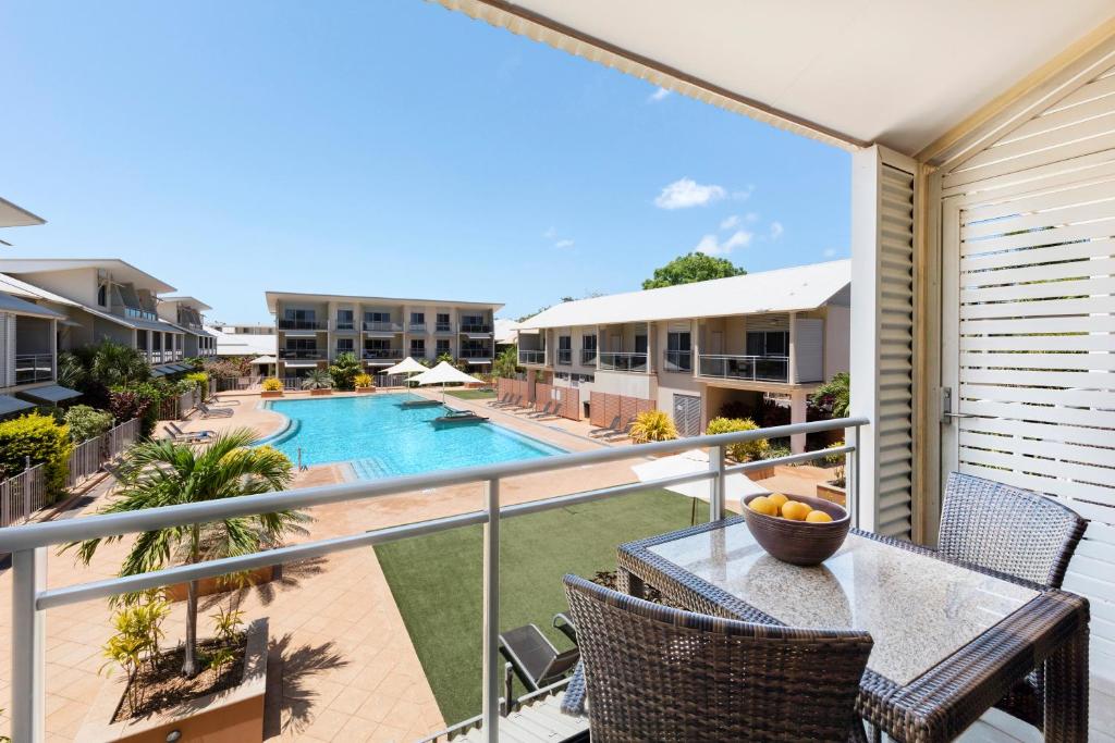 a balcony with a table and chairs and a swimming pool at Oaks Broome Hotel in Broome
