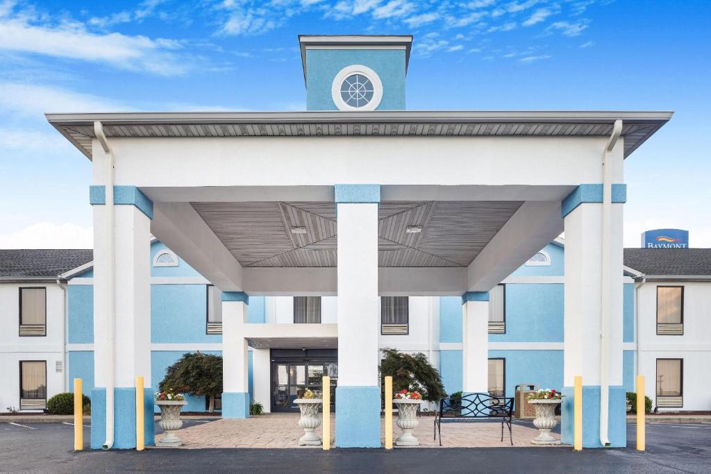 a large white building with a clock tower on top at Baymont by Wyndham Madisonville in Madisonville