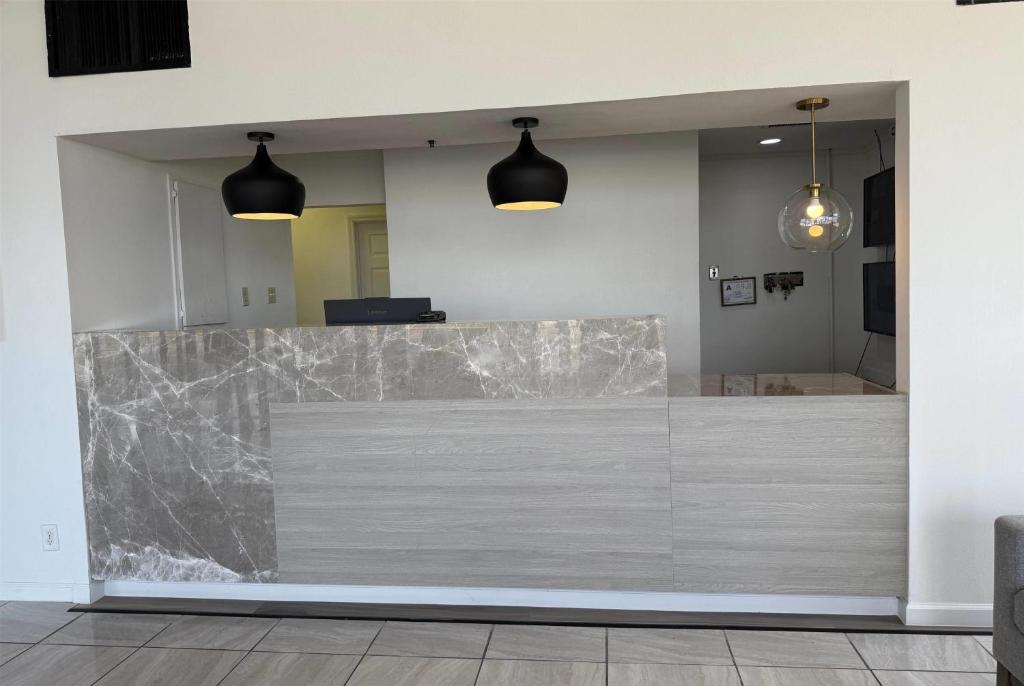 a large marble counter in a room with two pendant lights at Ramada by Wyndham Lumberton NC North in Lumberton