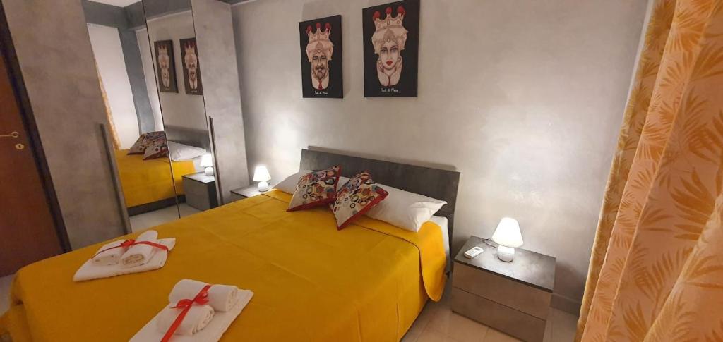 a bedroom with a yellow bed with towels on it at Capo D'Argento Home in SantʼAlessio Siculo