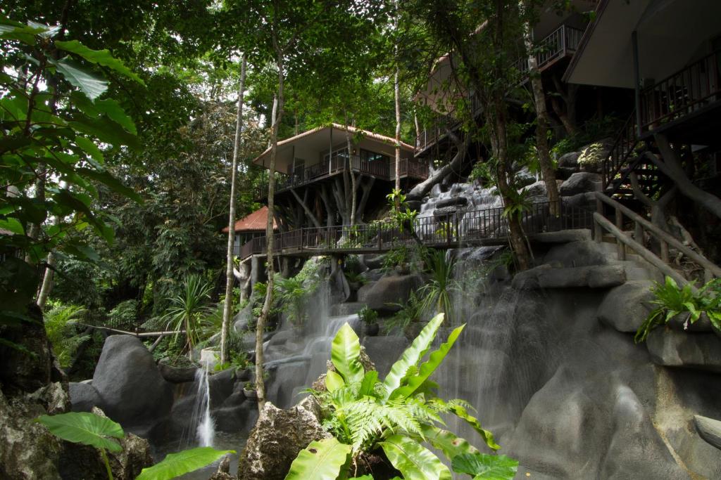 a waterfall in front of a resort in the jungle at Rock and Tree House Resort in Khao Sok National Park