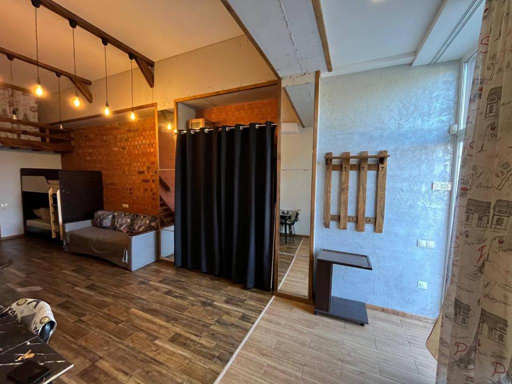 Una habitación con una cortina negra y un sofá. en Стадия лофт 2, en Chornomorsk