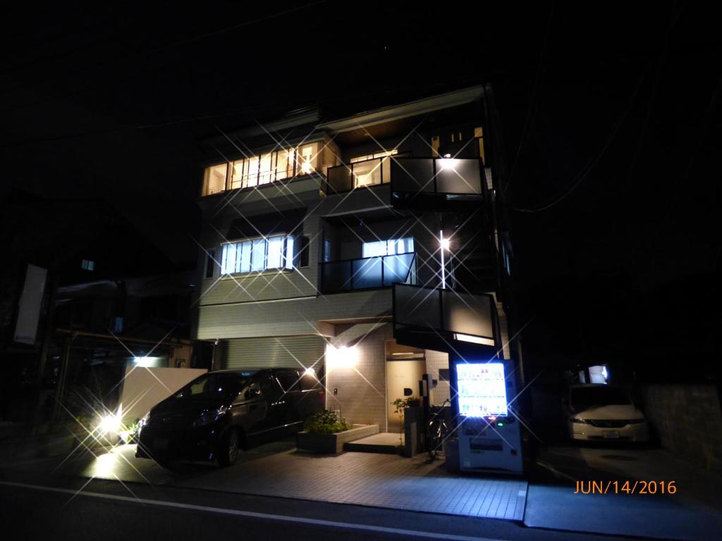 a tall building with cars parked in front of it at night at SAIZEN Matsumuro stay in Kyoto