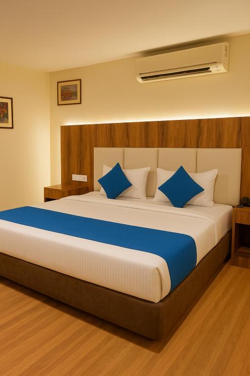 une chambre avec un grand lit avec des oreillers bleus dans l'établissement Via Ringred Palace, à Bangalore