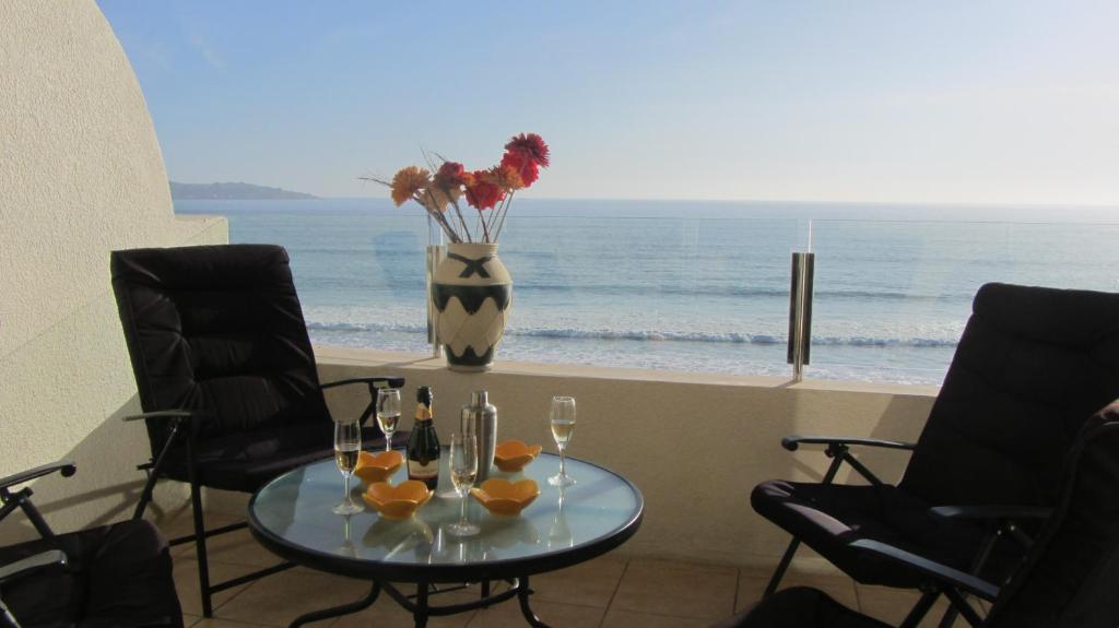 a table with wine glasses and a vase with flowers at Vacations in La Serena in La Serena
