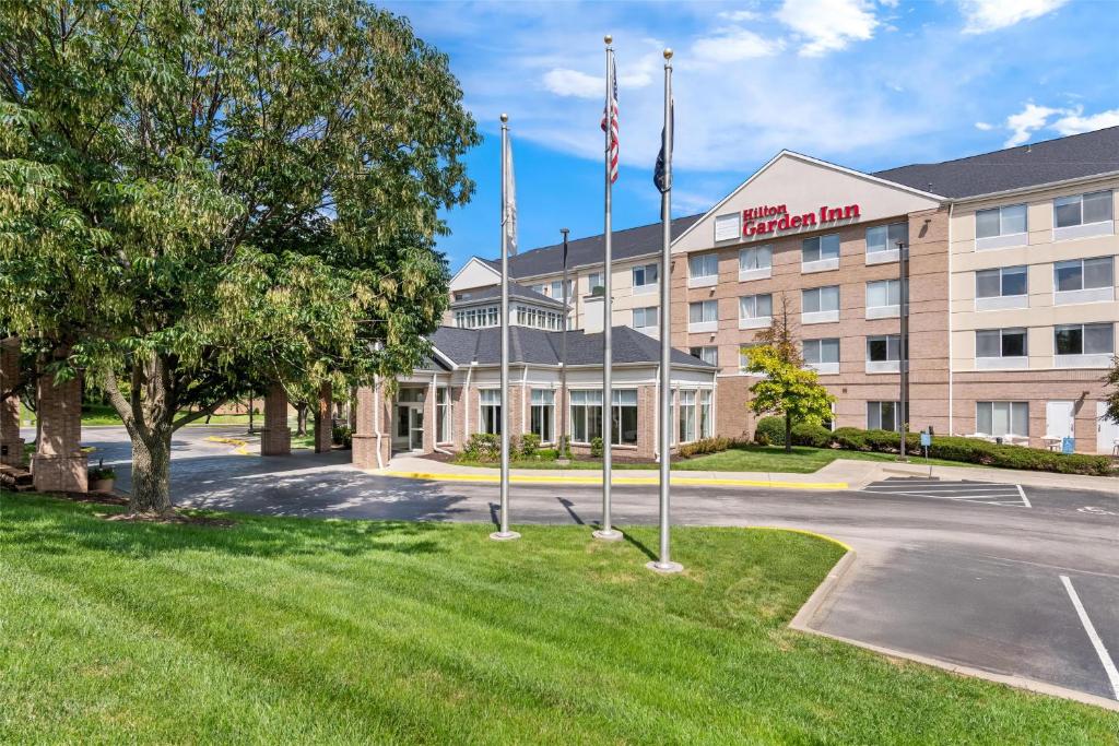 a hotel with flags in front of a building at Hilton Garden Inn Overland Park in Overland Park
