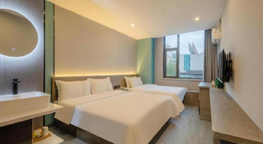 Ένα ή περισσότερα κρεβάτια σε δωμάτιο στο 7 Days Inn Weihai High-Speed Railway & Bus Station