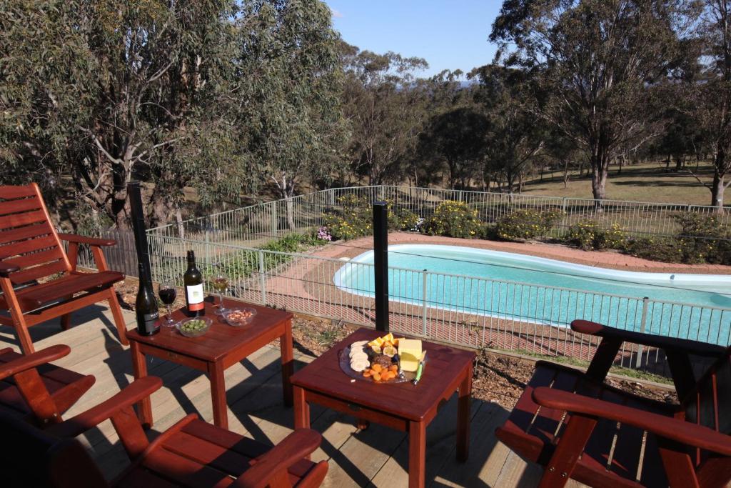 a pool with two chairs and a table with wine bottles at Englewood Ridge in Lovedale