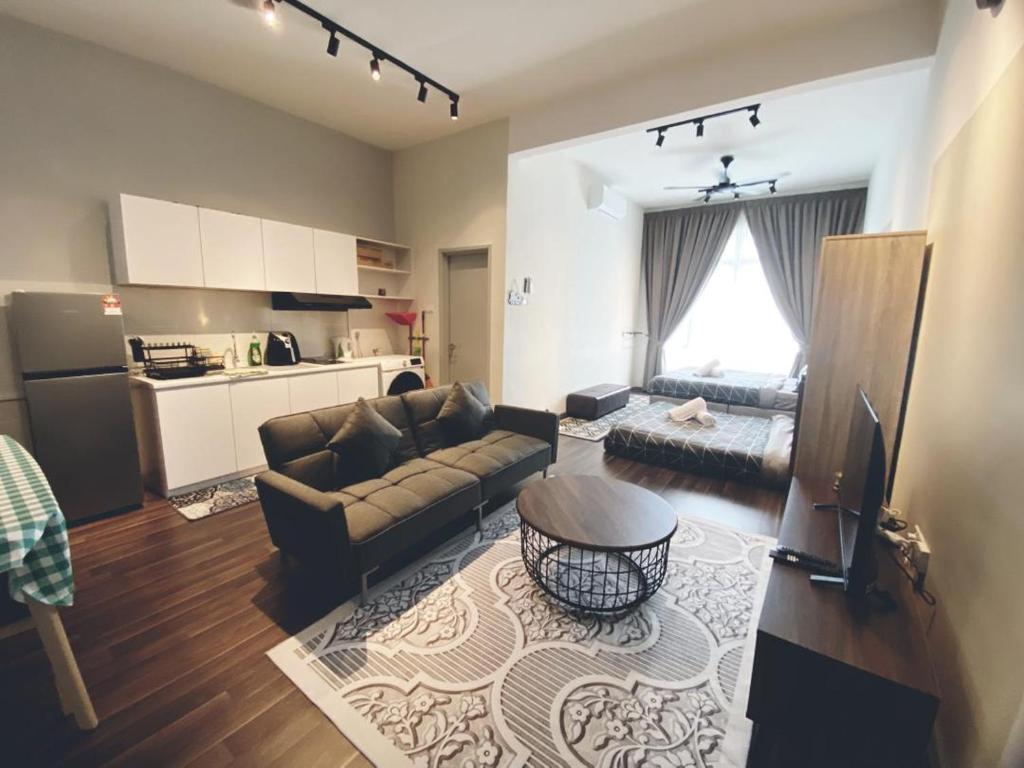 Una sala de estar con un sofá y una cocina. en LV10 The Greywoodz 1-4pax Kuantan, en Kuantan