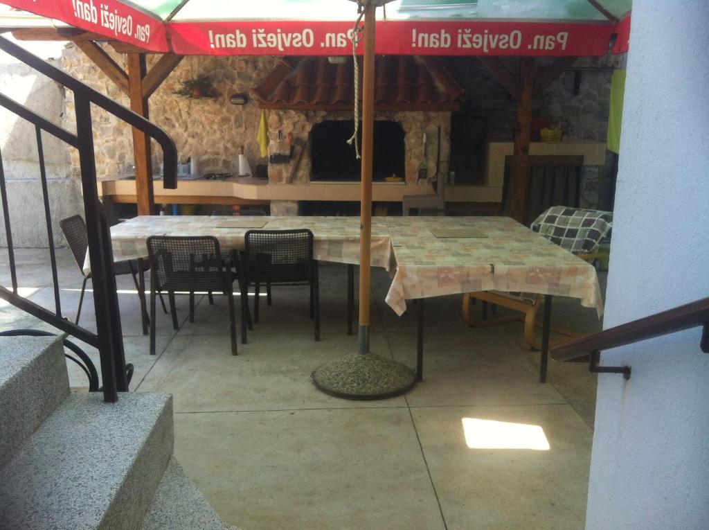 a table and chairs under an umbrella on a patio at Rooms Ivica Vodice in Vodice