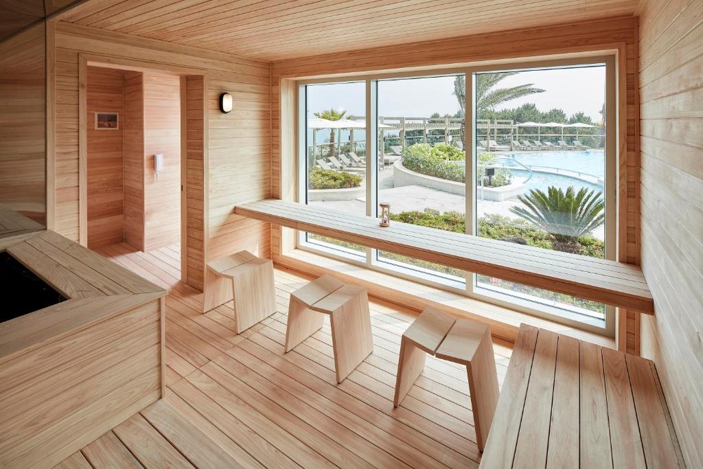 a sauna with a bench and a large window at The Shilla Jeju in Seogwipo