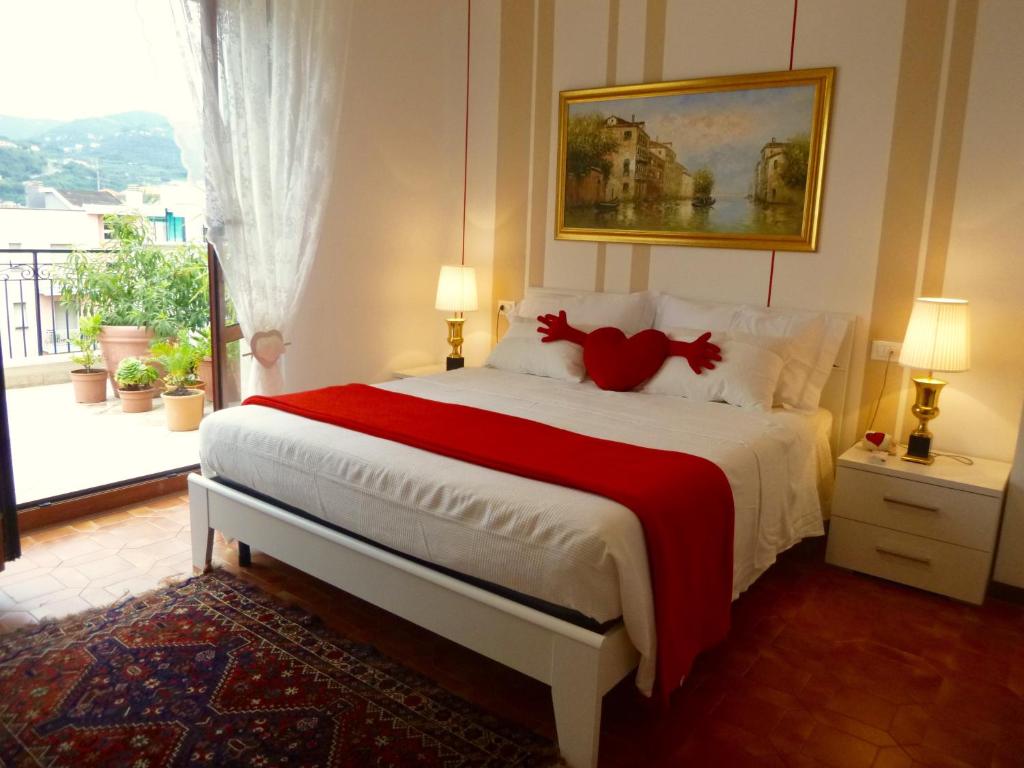 un dormitorio con una cama con un animal de peluche rojo en I Love Pietra Ligure, en Pietra Ligure