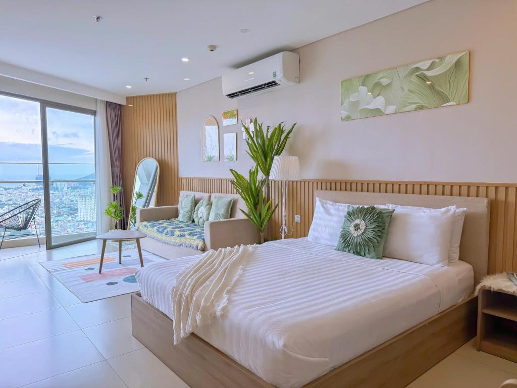 a bedroom with a large bed and a couch at HomeAway - The Sóng Vũng Tàu LUX Condotel in Vung Tau