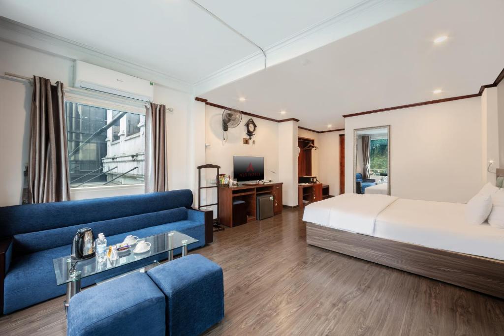 a bedroom with a bed and a blue couch at A25 Hotel - 57 Quang Trung in Hanoi