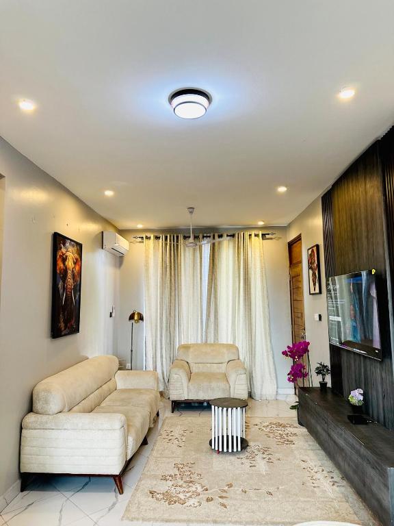 a living room with two couches and a tv at Bsm Villas & Apartment 01 in Dar es Salaam