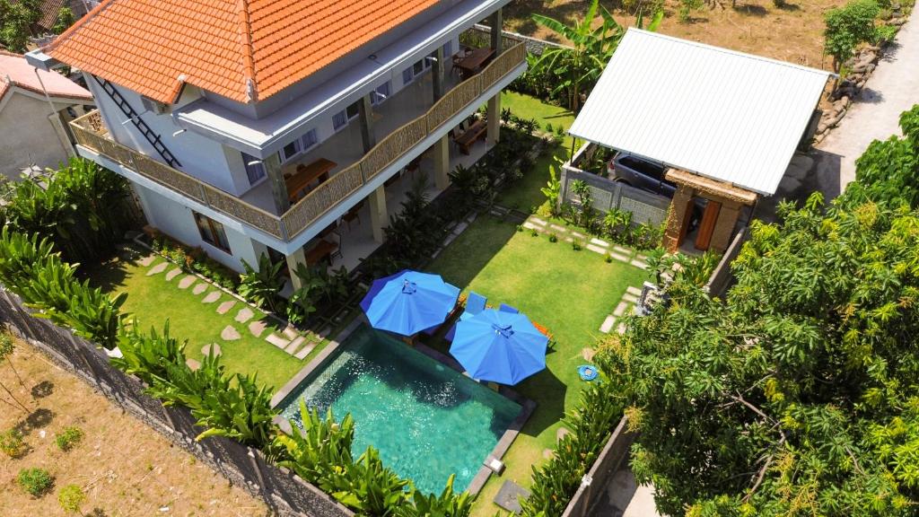 una vista aérea de una casa con piscina y sombrillas en The Raka Villa Amed, en Amed