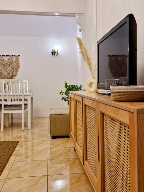 a living room with a television on a wooden entertainment center at Tranquil Condo in Zamalek in Cairo